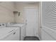 Laundry room featuring white washer and dryer, door, and shelving at 1046 Upchurch Farm Ln, Cary, NC 27519