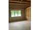 Unfinished room frame with studs, a window and visible insulation, highlighting the bare structure and construction stage at 107 Parkland Dr, Pittsboro, NC 27312