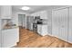 Well-lit kitchen featuring white cabinets, stainless steel appliances, and light-colored wood floors at 108 New Castle Ct, Youngsville, NC 27596