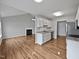 Open-concept kitchen with granite countertops, white cabinetry, stainless appliances, and wood flooring at 108 New Castle Ct, Youngsville, NC 27596