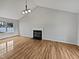 Open living room with a fireplace, vaulted ceiling, and new light brown floors at 108 New Castle Ct, Youngsville, NC 27596
