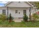 Close up of the charming exterior of a home showcasing the entry door, windows, and decorative wrought-iron porch supports at 1103 Gaston St, Smithfield, NC 27577