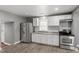 Well-lit kitchen features stainless steel appliances, white cabinets, modern countertops, and laminate flooring at 1103 Gaston St, Smithfield, NC 27577