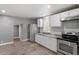 Updated kitchen featuring stainless steel appliances, gray walls, white cabinetry, and wood laminate floors at 1103 Gaston St, Smithfield, NC 27577