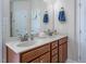 Bathroom features a double vanity sink, decorative mirror, and wood cabinets at 1176 Andrews Ct, Creedmoor, NC 27522