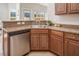 Kitchen area featuring stainless steel dishwasher, wooden cabinets, and a view to the backyard at 1176 Andrews Ct, Creedmoor, NC 27522
