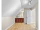 Attic room featuring wood look floors, storage cabinets and a door to another room at 1301 Merrington Cir, Raleigh, NC 27615