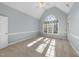 Bedroom with carpet floors, vaulted ceiling, crown molding, and a large arched window at 1301 Merrington Cir, Raleigh, NC 27615