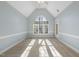 Bright bedroom with carpet floors, vaulted ceiling, crown molding, large windows, and a door to the backyard at 1301 Merrington Cir, Raleigh, NC 27615
