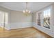 Elegant dining room with hardwood floors, classic wainscoting, and a stylish chandelier fixture at 1301 Merrington Cir, Raleigh, NC 27615