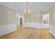 Elegant dining room with hardwood floors, classic wainscoting, a stylish chandelier, and wet bar at 1301 Merrington Cir, Raleigh, NC 27615
