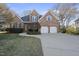 Charming brick home boasts a well-manicured lawn and a two-car garage with a spacious driveway at 1301 Merrington Cir, Raleigh, NC 27615