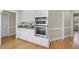 Kitchen featuring stainless-steel ovens, granite counters, white cabinets, and hardwood floors at 1301 Merrington Cir, Raleigh, NC 27615