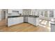 Bright kitchen featuring granite counters, white cabinets, stainless appliances, and hardwood flooring at 1301 Merrington Cir, Raleigh, NC 27615