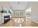 Open concept living room featuring a fireplace, hardwood floors, high ceilings, and ample natural light at 1301 Merrington Cir, Raleigh, NC 27615