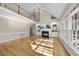 Spacious living room with hardwood floors, a fireplace, and large windows, offering abundant natural light at 1301 Merrington Cir, Raleigh, NC 27615