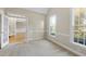 Neutral room featuring chair railing, two windows, and a doorway leading to another room at 1301 Merrington Cir, Raleigh, NC 27615