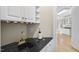 Attractive wet bar with black countertop, undermount sink and gold fixtures, plus wine storage at 1301 Merrington Cir, Raleigh, NC 27615