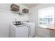 Functional laundry room with a washer, dryer, shelving, and a window for natural light at 140 Ashberry Ln, Franklinton, NC 27525