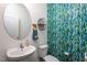 Stylish powder room with a pedestal sink, round mirror, and decorative wallpaper at 140 Ashberry Ln, Franklinton, NC 27525