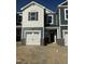 Charming townhome featuring a white garage door, stone accents, and a mix of shingle and horizontal siding at 17 Silver Pne Dr, Angier, NC 27501