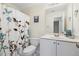 A well-lit bathroom featuring a floral shower curtain, white vanity, and neutral wall paint at 1709 Heisser Ln, Fuquay Varina, NC 27526