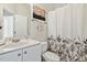 Well-lit bathroom with a single sink vanity, decorative shower curtain and a door to the toilet at 1709 Heisser Ln, Fuquay Varina, NC 27526