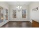 Sunlit dining room with wood flooring, a chandelier, and backyard views through windows at 1709 Heisser Ln, Fuquay Varina, NC 27526