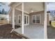 Covered patio featuring neutral siding and double doors leading to the home's interior at 1709 Heisser Ln, Fuquay Varina, NC 27526