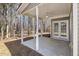 Covered patio with white pillars, ceiling fan, and view of a wooded backyard at 1709 Heisser Ln, Fuquay Varina, NC 27526