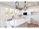 Modern white kitchen with an island, stainless appliances, and bright natural light at 172 Kobus Ct, Garner, NC 27529
