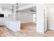 Open-concept kitchen and living area with hardwood floors and modern white cabinets at 172 Kobus Ct, Garner, NC 27529