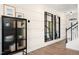 Stylish hallway featuring modern storage unit, a sleek mirror, and beautiful flooring leading to staircase at 176 Kobus Ct, Garner, NC 27529