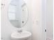Bright powder room featuring a pedestal sink, oval mirror, and sleek fixtures at 18 Twin Birch Dr, Angier, NC 27501