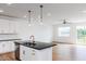 An island with a black countertop, a gold faucet, and white cabinets complements this home's open kitchen at 18 Twin Birch Dr, Angier, NC 27501