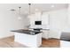 Bright kitchen featuring white cabinets, an island with dark countertops, and modern pendant lights at 18 Twin Birch Dr, Angier, NC 27501