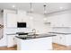 Modern kitchen with white cabinets, a black countertop island, and pendant lighting at 18 Twin Birch Dr, Angier, NC 27501