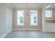 Dining area with modern chandelier, large windows, and built-in cabinet, bathed in natural light at 1805 Bright Lantern Way, Wendell, NC 27591