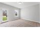 Bright bedroom with neutral carpet, large window offering a view, and a door leading to the outside at 1917 Fishamble St, Fuquay Varina, NC 27526