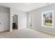 Cozy bedroom featuring plush carpet, natural light from a window and door, with attached bathroom access at 1917 Fishamble St, Fuquay Varina, NC 27526