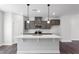 Open concept kitchen with a spacious center island, modern gray cabinetry, and stainless steel appliances at 1917 Fishamble St, Fuquay Varina, NC 27526