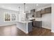 Well-lit kitchen features a center island, gray cabinetry, and stainless steel appliances at 1917 Fishamble St, Fuquay Varina, NC 27526