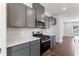 Contemporary kitchen with gray cabinetry, stainless steel appliances, and bright white countertops at 1917 Fishamble St, Fuquay Varina, NC 27526