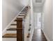 Elegant staircase features hardwood treads, white risers, and stained wood posts with white railings leading upstairs at 1917 Fishamble St, Fuquay Varina, NC 27526