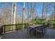 Back deck with table and chairs, surrounded by mature trees at 201 Adams Way, Chapel Hill, NC 27516