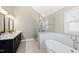 Well-lit bathroom with double sink vanity, a separate glass shower, and elegant soaking tub with fixtures at 201 Adams Way, Chapel Hill, NC 27516