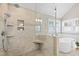 Modern bathroom featuring a glass shower with built-in bench, a soaking tub, and neutral tiling at 201 Adams Way, Chapel Hill, NC 27516