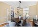 Elegant dining room featuring a wooden table, stylish chandelier, and seamless flow to the kitchen at 201 Adams Way, Chapel Hill, NC 27516