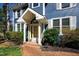 Inviting front entrance with a yellow door, brick pathway, and well-maintained landscaping at 201 Adams Way, Chapel Hill, NC 27516
