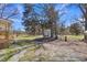 View of the backyard highlighting a storage shed and wooded surroundings from the porch of the home at 2080 Saint Paul Church Rd, Roxboro, NC 27574